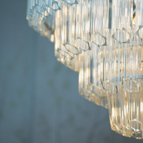 large clear glass chandelier in a tiered formation in a project by Tile House Studio interior designers