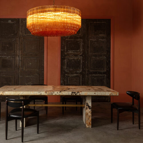 Grande Amber Amaro - large amber drum chandelier in mid-century Murano glass style hanging over a Patagonia quartzite dining table