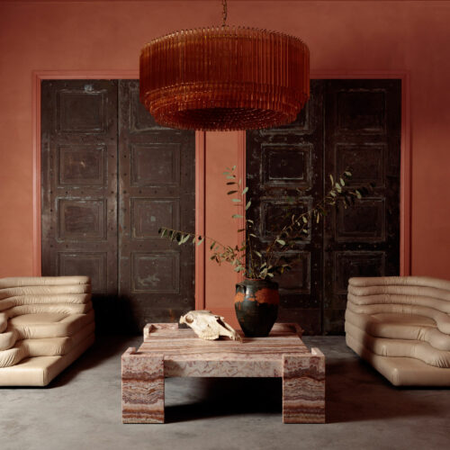 Grande Amber Amaro - large amber drum chandelier in mid-century Murano glass style hanging over a red square marble coffee table